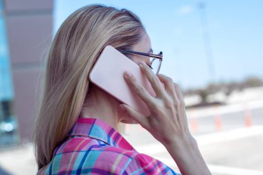 Bir kadının el ele tutuşup açık havada telefon kullanmasının yakın çekimi.. 