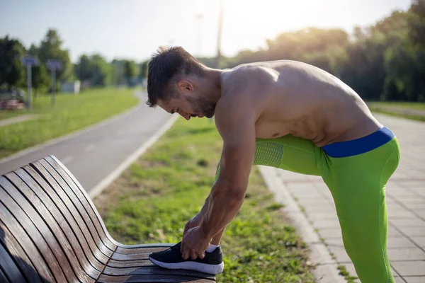 若いスポーツマンがストレッチ運動をし 公園で朝のトレーニングの準備をしています フィットネス スポーツ ライフスタイルのコンセプト — ストック写真