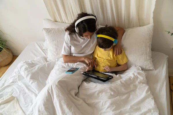 Mamá y el niño estudian juntos: mamá ayudar a su hijo con la educación preescolar formación viendo cursos en línea —  Fotos de Stock
