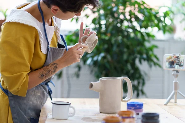 Girl vlogger make online video lesson of process of sculpturing pottery, shaping cap for ceramic jug — Stock Photo, Image