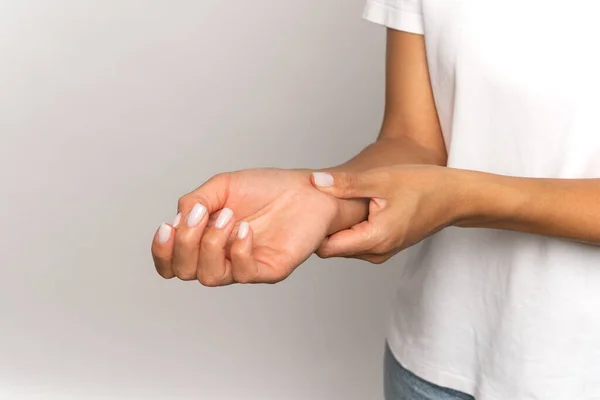 Woman pressing fingers on wrist check pulse. Female touch arm, measure heart beat or blood pressure