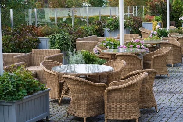 Порожня тераса відкритого кафе з плетеними меблями та вирощуванням квітів у горщику для літніх розваг — стокове фото