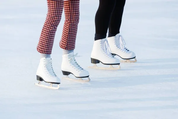 オープンスケートリンクで冬のスケートで女性の足の閉鎖 冬の午後には2人の友達のアイススケートが一緒にスケートします 野外活動のコンセプト — ストック写真