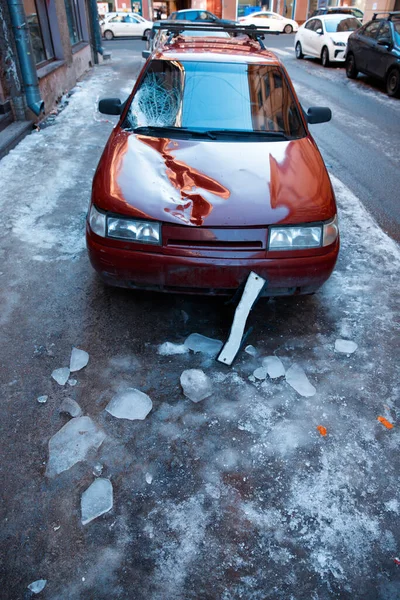 建物の屋根から氷 氷のブロック の作品を落下した後 車の壊れたフロントガラスと車のボンネット 屋根からの氷の除去不良は 車両への損傷をもたらします — ストック写真