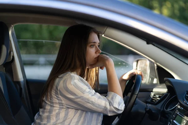 Een dronken meisje in een auto. Ongelukkig vermoeide jonge vrouw in voertuig met hoofdpijn of overdracht — Stockfoto