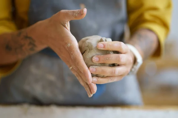 Vrouwelijke pottenbakker handen gieten rauwe klei. Vrouw keramist in schort voor te bereiden voor het vormgeven van aardewerk — Stockfoto