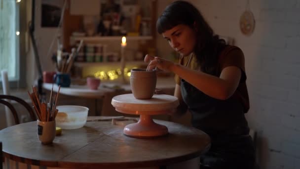 Muchacha ceramista disfrutar de la ocupación del trabajo a mano trabajando con cerámica en pequeño taller de cerámica acogedor estudio — Vídeos de Stock