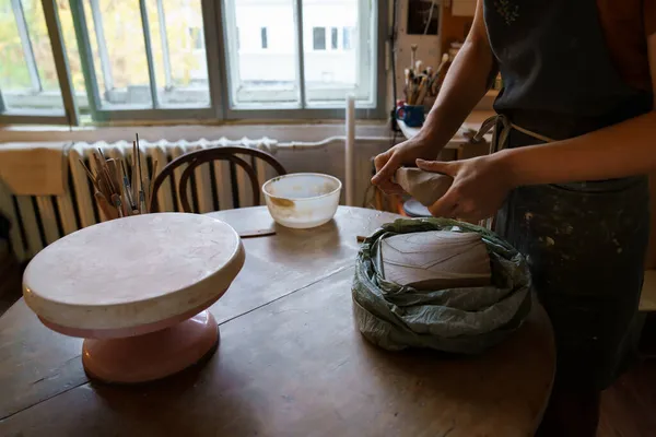 Woman ceramics artist molding raw clay for sculpturing pottery on potter wheel. Female art teacher — Stock Photo, Image