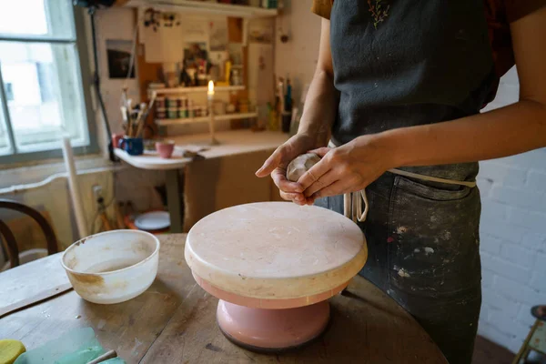 陶艺家女性在砂轮上塑造粘土.陶瓷专家在围裙工作与原始陶器为陶工 — 图库照片