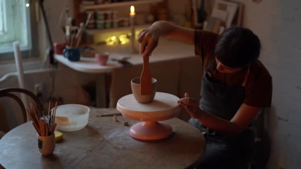 Çömlekçilikte atmosfer: önlüklü sanatçı kadın küçük yaratıcı alanda el sanatları sofra takımı oluşturuyor — Stok video