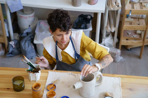 Taller de cerámica propietario mujer crear alfarero de arcilla en el estudio decorar utensilios de cocina de arcilla seca con pinturas —  Fotos de Stock