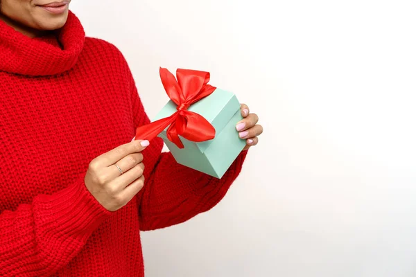 Kobieta w przytulnym swetrze otwartym pudełku prezentów. Afrykanka trzyma prezent świąteczny. Sezonowa sprzedaż zimowa — Zdjęcie stockowe