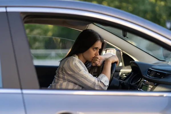 累了的不舒服的女人在车里的司机座位上。因逃避虐待丈夫而筋疲力尽的女性妻子 — 图库照片