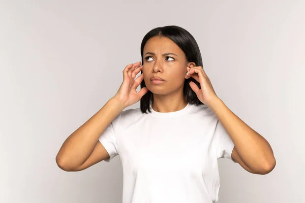 Mujer africana irritada tapando las orejas estresada con el ruido del vecino mira hacia arriba con cara molesta — Foto de Stock