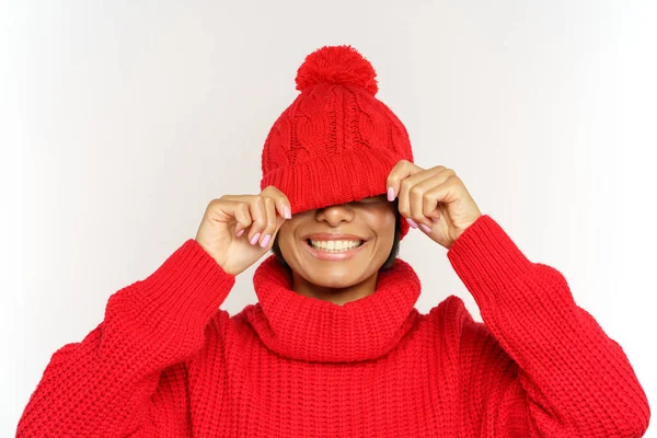 Vtipná černoška skrývá oči pod módní pletený klobouk šťastný úsměv. Nadšený africký žena se baví — Stock fotografie