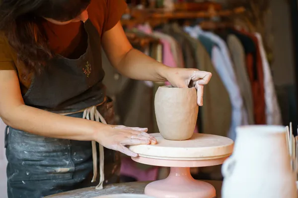 stock image Ceramist female concentrated shaping potter jug in studio. Woman visit ceramics classes after work