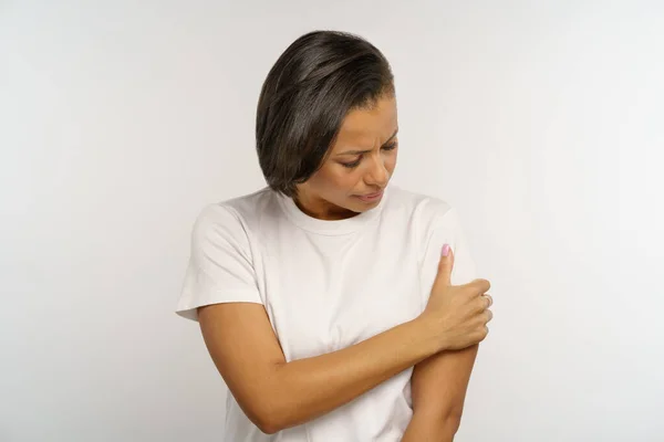 Gestresste zwarte vrouw lijdt aan pijn in de arm raken gewonde schouder. Jonge vrouw met botbreuk — Stockfoto