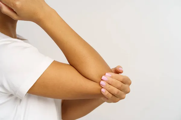 Afrikaanse vrouw lijdt aan pijn in de elleboog masserende hand. Vrouw met pijnlijke arm of botbreuk — Stockfoto