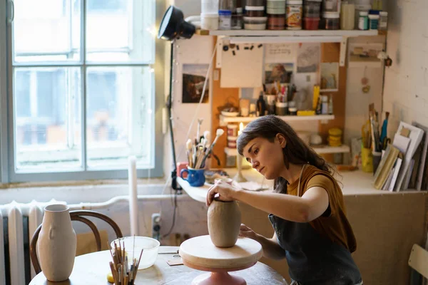 Vase de façonnage féminin talentueux en studio. Propriétaire d'atelier artistique femme occupée avec la poterie — Photo