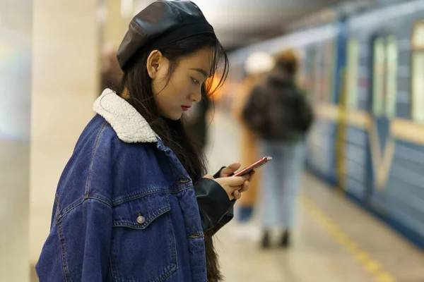 Telefon bağımlısı Çinli kız platformdaki sosyal medyadaki trene aldırış etmesin. — Stok fotoğraf