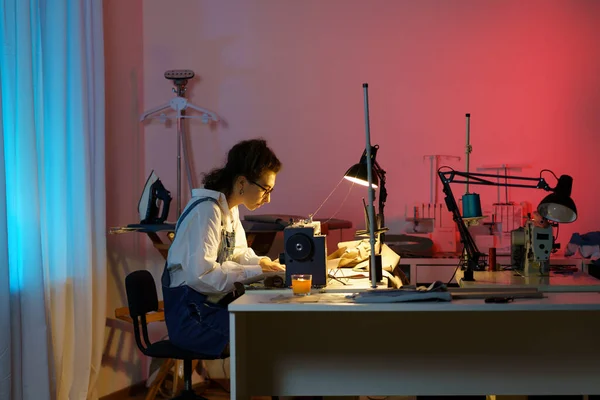 Tailoring business: young girl designer sewing clothes in studio using electric machine and fabric — Stock Photo, Image
