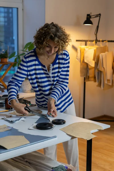 Kobieta krawiec wyciął próbki odzieży wzorów projektów papieru w pracowni projektowej fabryki odzieży — Zdjęcie stockowe