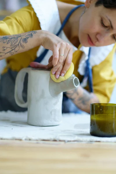 Kreativ kvinna som gjuter lerkruka i studion. Kvinnlig konstnär med tatueringar arbete på keramik i verkstad — Stockfoto