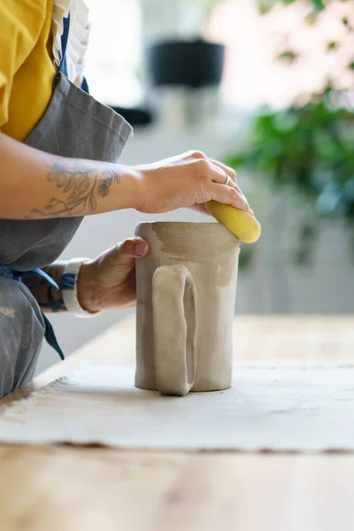 Młoda rzeźbiarka tworzy ceramiczne zastawy stołowe w studio. Kobieta ceramika artysta pracy z mokrej gliny — Zdjęcie stockowe