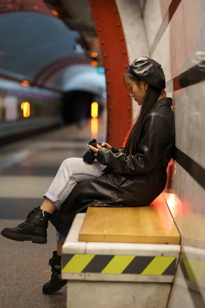 Joven asiático mujer calle estilo fotógrafo celebrar cámara mirando fotografía esperando para metro — Foto de Stock