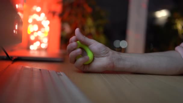 Male holding expander take a break from work, does exercise to prevent carpal tunnel syndrome. — Stock Video