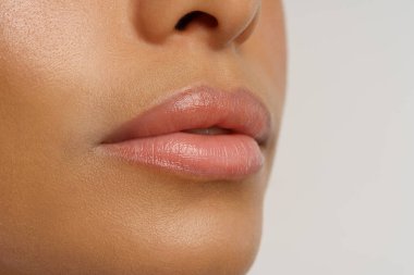 Dudak nemlendirici, kışın dudak nemlendirici kullanan Afro-Amerikan kadının nemlendirilmiş sağlıklı dudakları.
