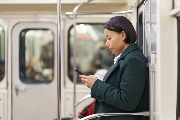 Metroda akıllı telefonlu üzgün Afro-Amerikan kadın, yorgun kadın ofis çalışanı toplu taşıma kullanıyor. — Stok fotoğraf