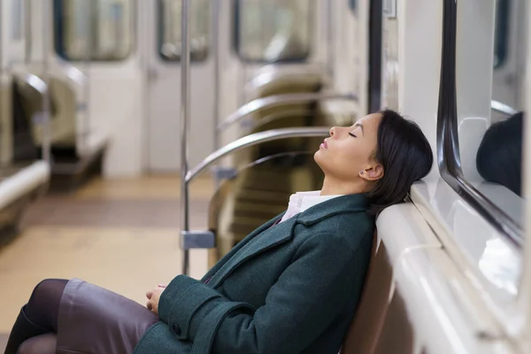 Volviendo tarde a casa. Dormir mujer de negocios africana en vagón subterráneo de metro vacío por la noche — Foto de Stock