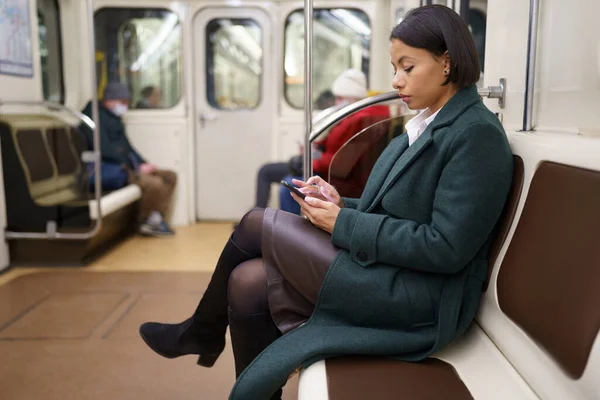 Sosyal medyada akıllı telefondan sörf yapan mutsuz Afrikalı kadın işten eve metroyla dönüyor. — Stok fotoğraf