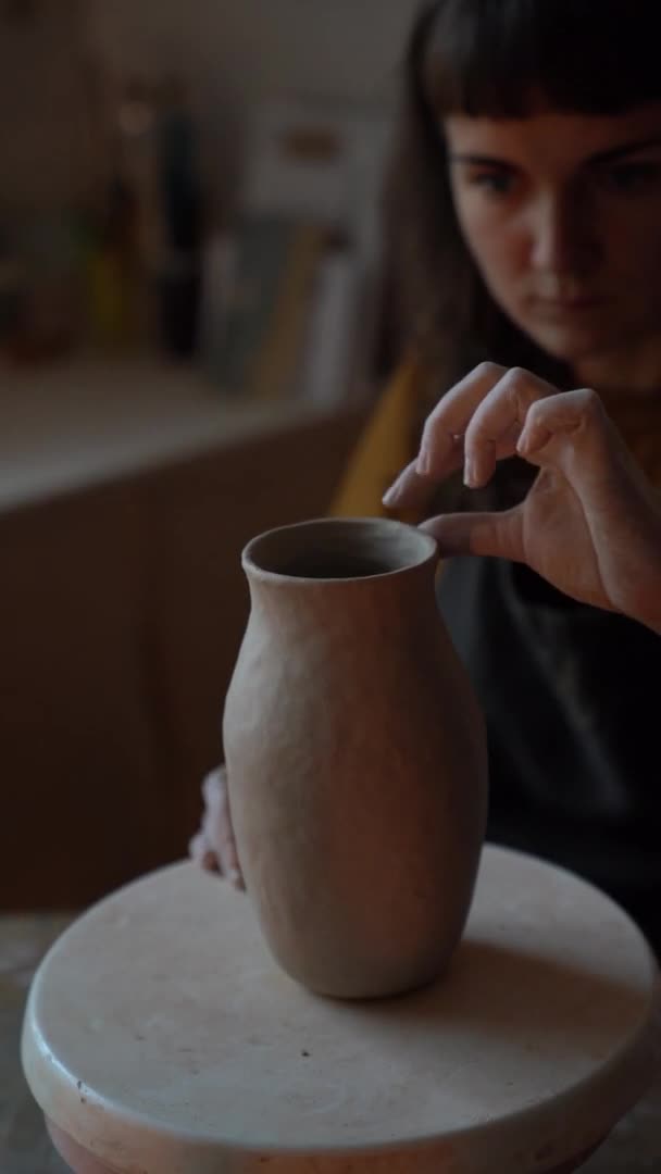 Muchacha ceramista joven centrada en dar forma a la arcilla hacer florero artesanal o jarra en el estudio durante las clases de arte — Vídeos de Stock