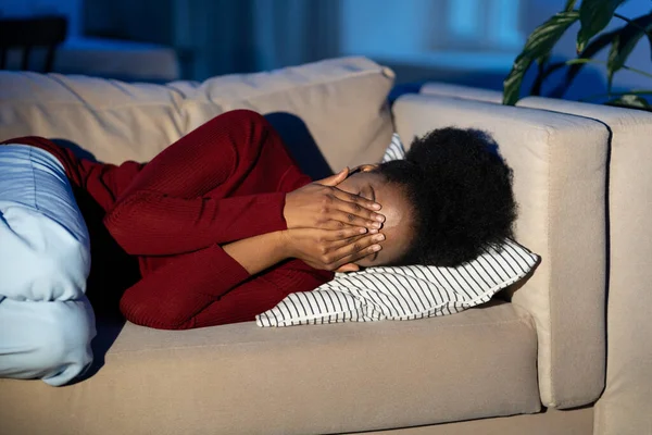 Frusztrált feldúlt afrikai nő fekszik a kanapén és sír, depressziós fekete nő otthon — Stock Fotó
