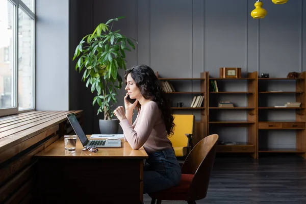 Ung affärskvinna konsultera klient via telefon titta på bärbar dator, diskutera projektet med kunden — Stockfoto