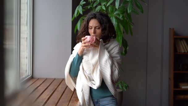 Shivering woman wrapped in blanket at windowsill at radiator suffer from climate control system lack — Stock Video