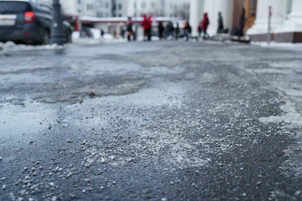 Reactivo químico de deshielo en carretera en invierno. El pavimento está salpicado de sal técnica —  Fotos de Stock