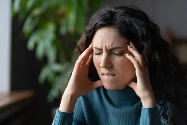 Mujer estresada infeliz que sufre de dolor de cabeza en el lugar de trabajo, mujer ansiosa que tiene dolor en la cabeza —  Fotos de Stock