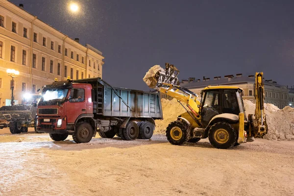 Professional snow removal equipment clearing Palace Square at night after intense snowfall in city — Zdjęcie stockowe