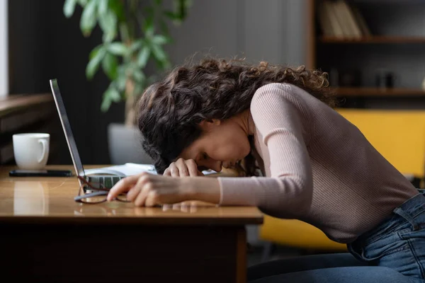 Een burn-out. Moe vrouwelijke werknemer zetten hoofd naar beneden op tafel, lijden aan chronische stress op het werk. — Stockfoto