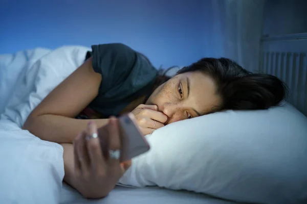 Unhappy girl follow cheating boyfriend in social media lying sleepless in bed suffer from insomnia — стоковое фото