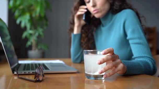 Ill woman with glass with dissolving aspirin pill call to doctor or employer asking for sick leave — Stockvideo