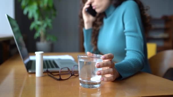 Ill woman drop effervescent aspirin or painkiller in glass of water talk to doctor on cellphone — Vídeo de Stock