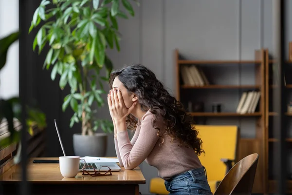 Disappointed female office worker struggling through task, tired overworked female employee — стоковое фото