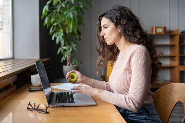 Focused businesswoman work on laptop hold expander in hand massaging muscles after computer overwork — Foto Stock