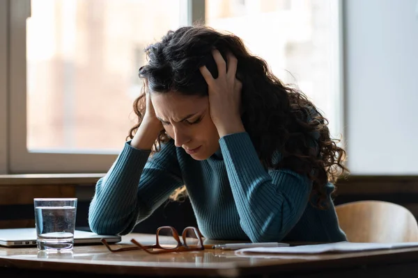 Unhappy woman overworked stressed sit at desk with closed laptop suffer from headache or depression — Stock Fotó