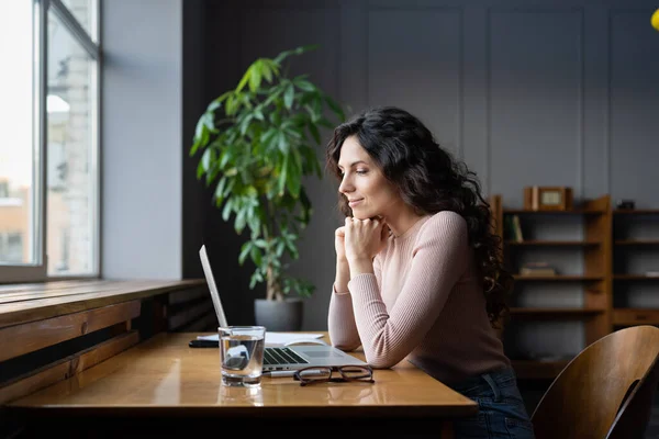 Щаслива бізнес-леді або позаштатний дизайнер дивіться на ноутбук усміхнений читати електронну пошту з позитивними відгуками — стокове фото