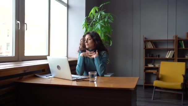 Femme souriante satisfait étirement après le travail d'ordinateur portable fait se détendre sur le lieu de travail assis avec les pieds sur le bureau — Video